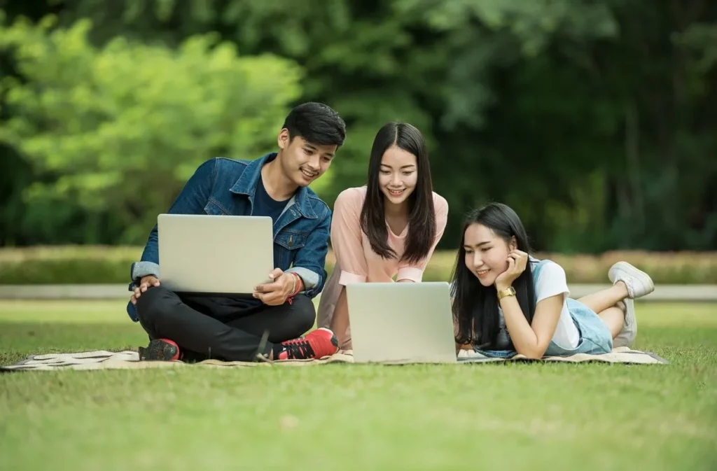 jóvenes en el cesped con portátiles