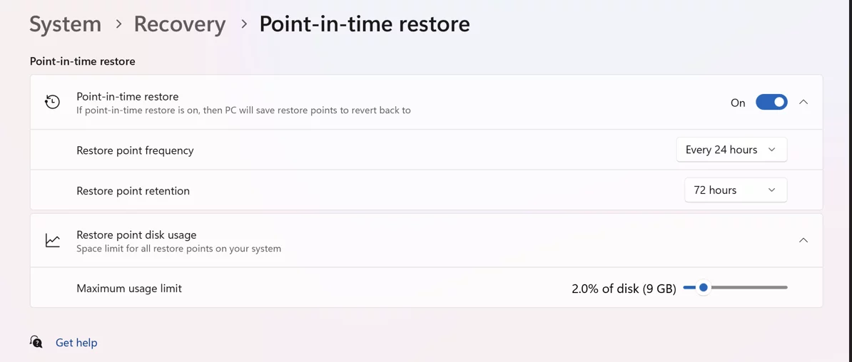 Portátil mostrando la pantalla de inicio de Windows 11 sobre una mesa Pantalla de configuración de Point-in-Time Restore en Windows 11 con opciones de frecuencia y retención